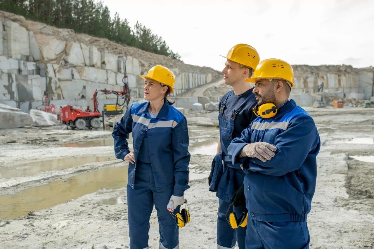 Three contemporary builders in uniform at granite quarry